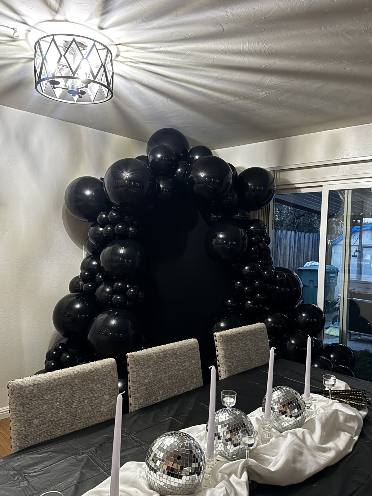 All black balloon arch with disco ball tablescape for a milestone birthday dinner